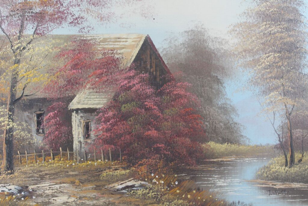 A print depicting a house and a river, which is available at our braderie